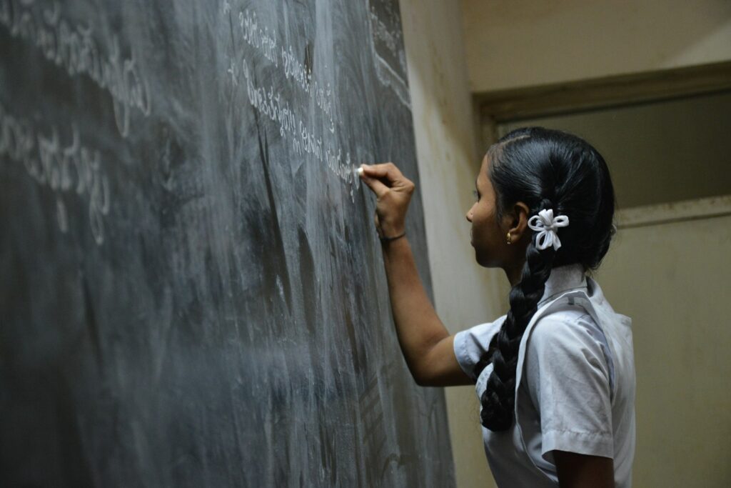 Student writing on a classroom chalkboard