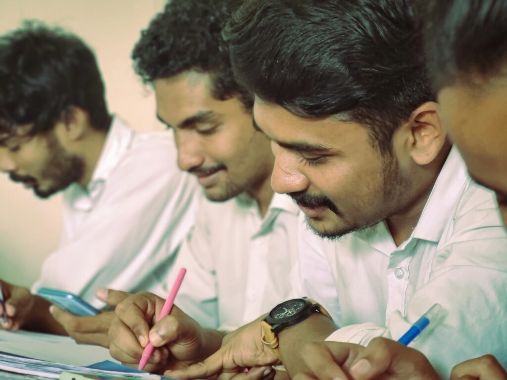Students writing at a table during a class